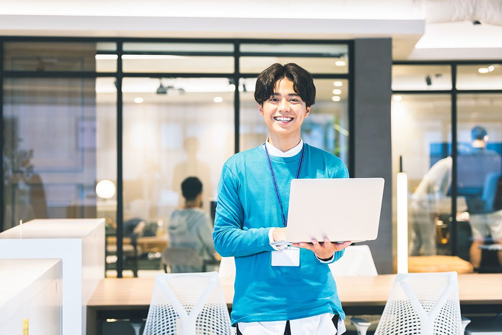 パソコンを持って笑顔のスタッフ