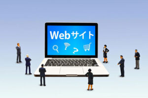 Webサイトを表示したパソコンと、その周りに集まる人々のイメージ